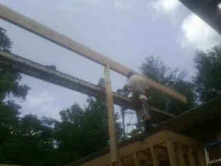 Carpenter setting a ridge beam over a new addition frame — Ice Dam Removal by Roofing Brothers in Live Oak
