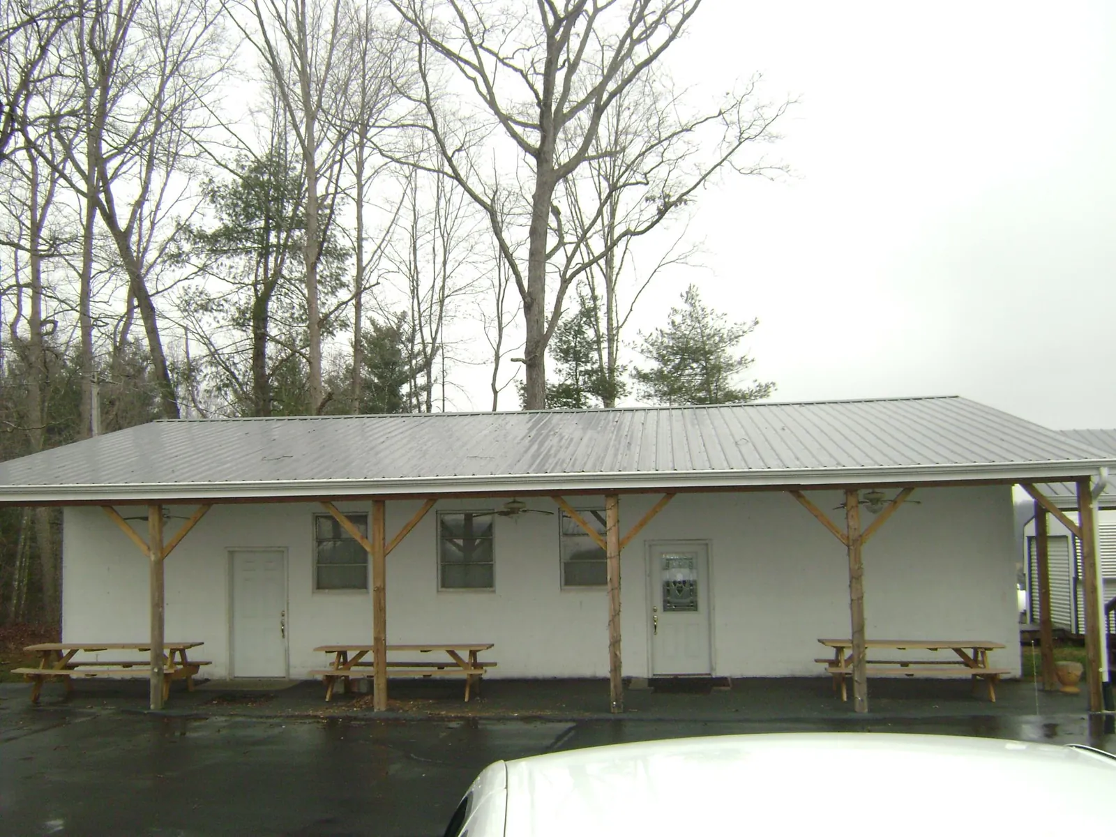 Gray metal roof over a block building with a timber post porch in Live Oak