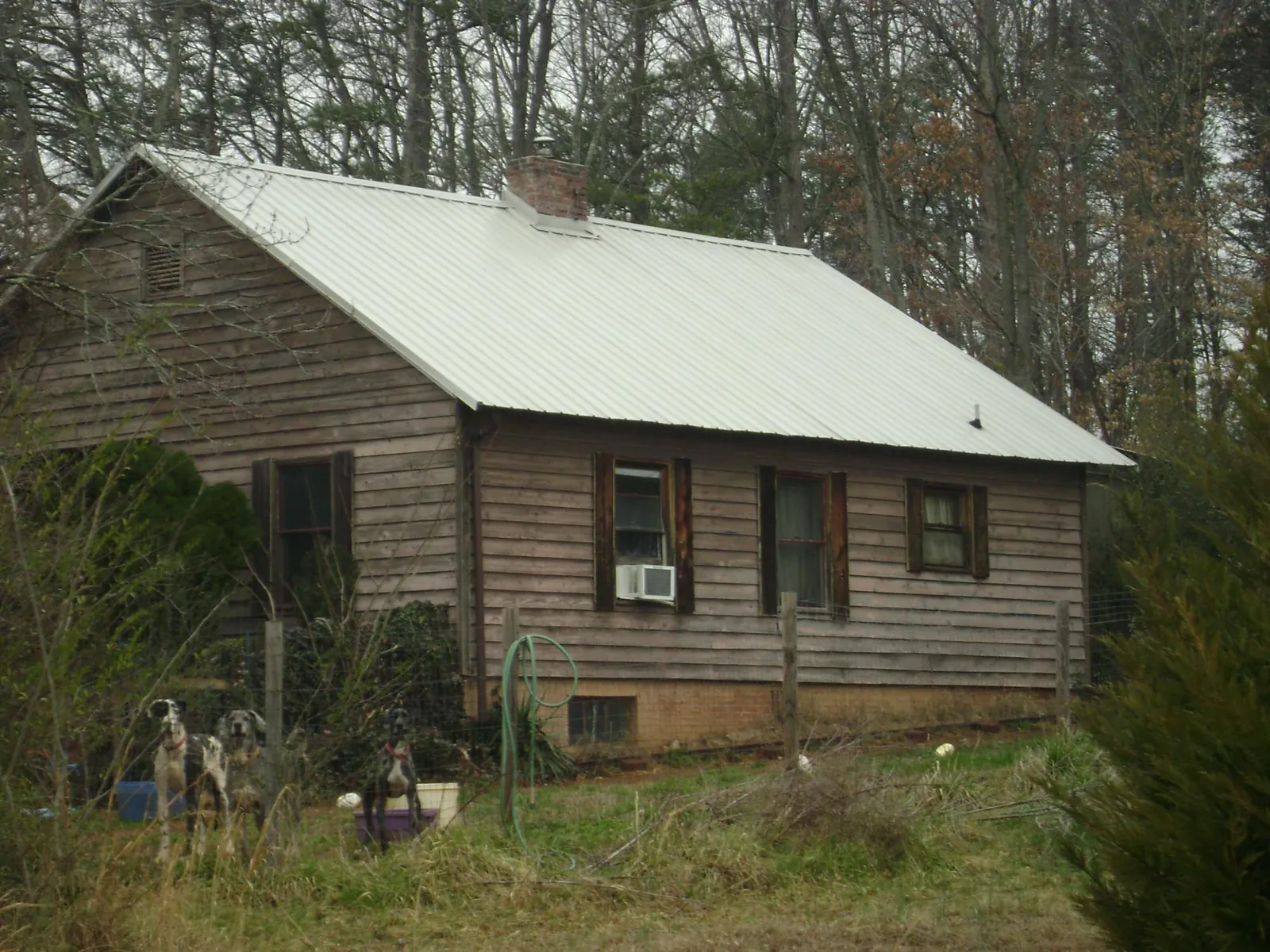 White metal roof on an old wood sided farmhouse, from a Metal Roof Installation job in Live Oak